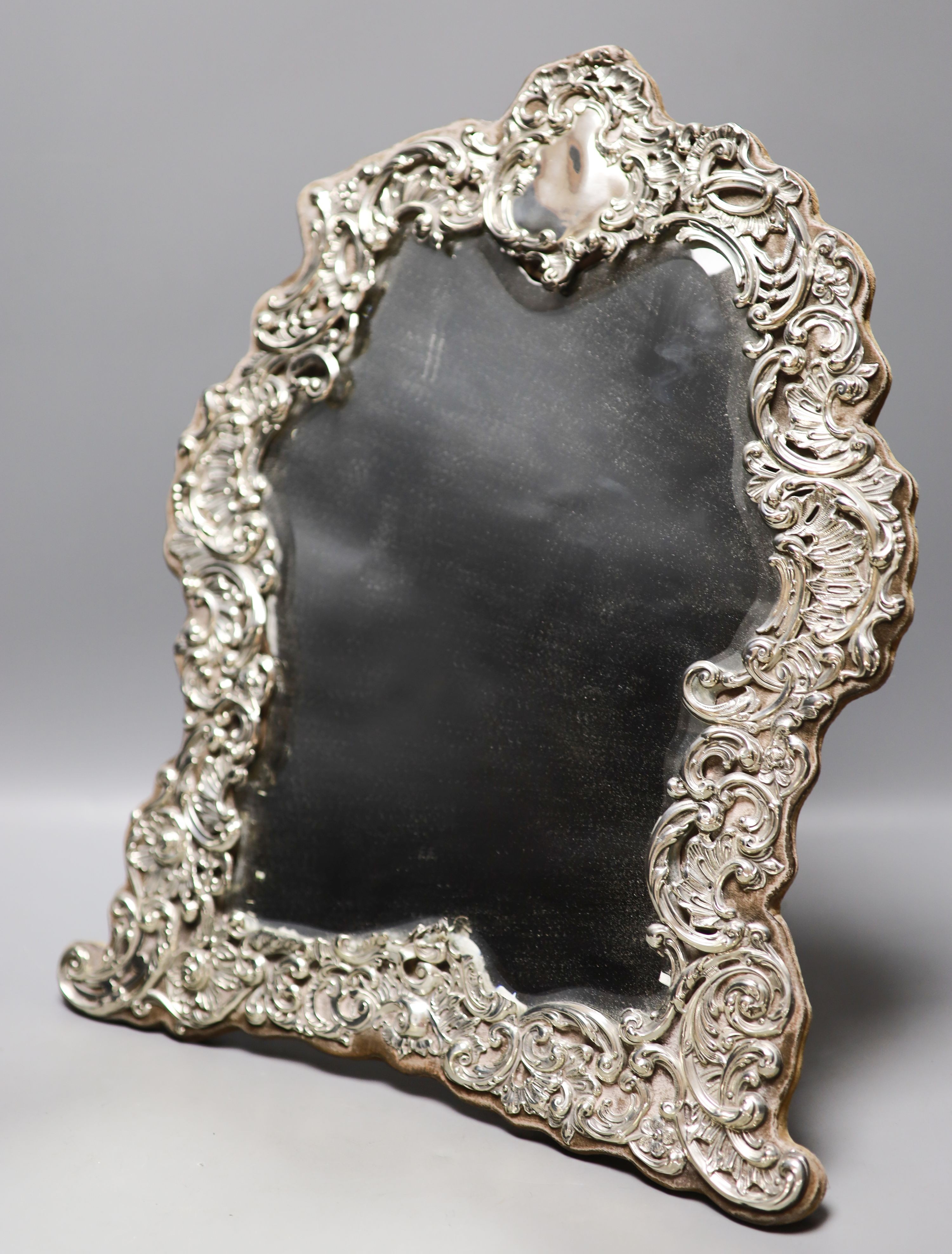 An Edwardian repousse silver mounted easel mirror, with foliate scroll decoration, Chester, 1902, height 45.7cm.